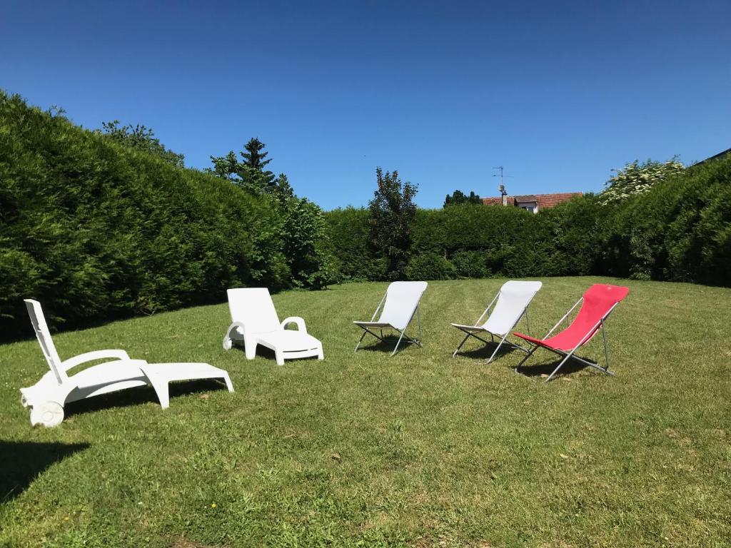 un groupe de chaises longues assises dans l'herbe dans l'établissement Le Chalet, à Bouchoir