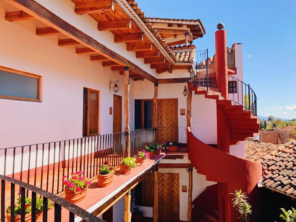 a balcony of a house with potted plants at Posada la Manzanilla in La Manzanilla de la Paz