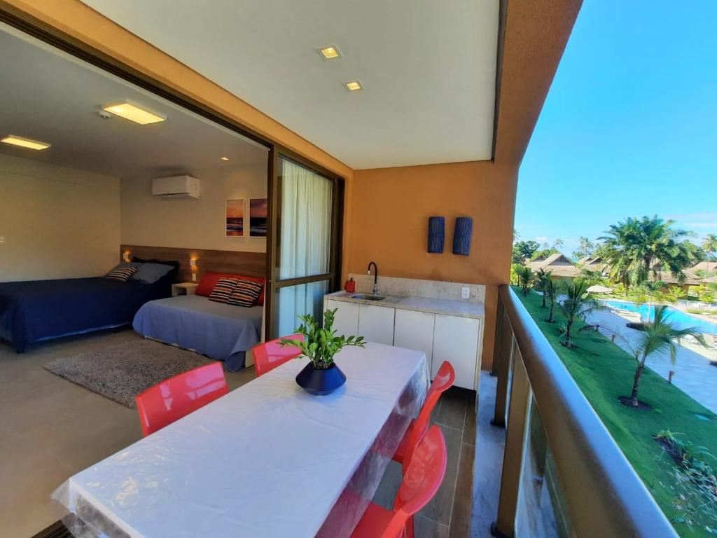 a kitchen and living room with a table and chairs at Ecoresort - Praia dos Carneiros in Rio Formoso