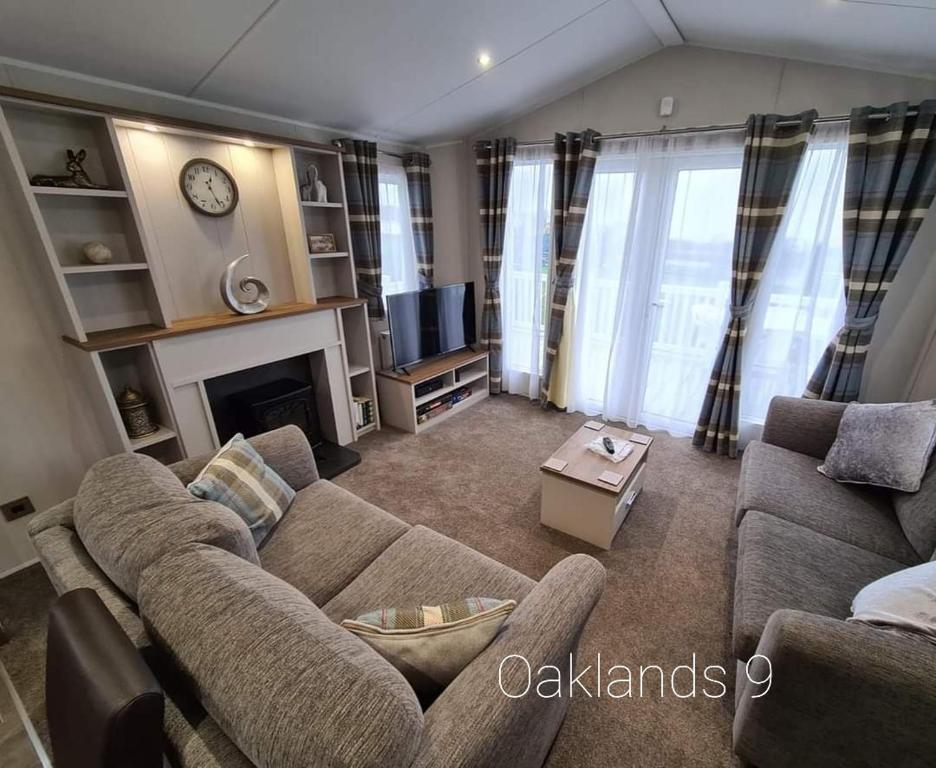 uma sala de estar com um sofá e uma lareira em Modern Sea View Holiday Home Isle of Wight em Porchfield