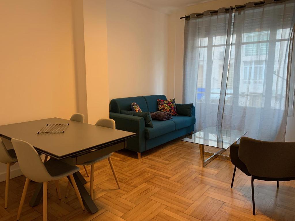 un salon avec un canapé bleu et une table dans l'établissement Promenade des Anglais à côté du Negresco, à Nice