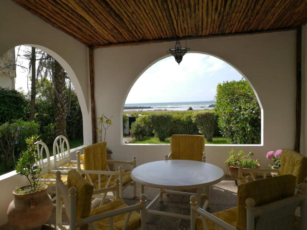 um pátio com uma janela arqueada, uma mesa e cadeiras em Maison Etoile De Mer 1 em Skhirat