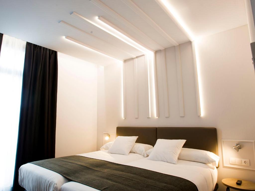 מיטה או מיטות בחדר ב-Hotel Lux Santiago
