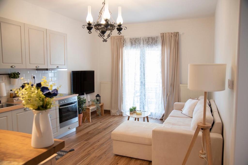 un soggiorno con divano bianco e una cucina di Casa Di Famiglia a Salonicco