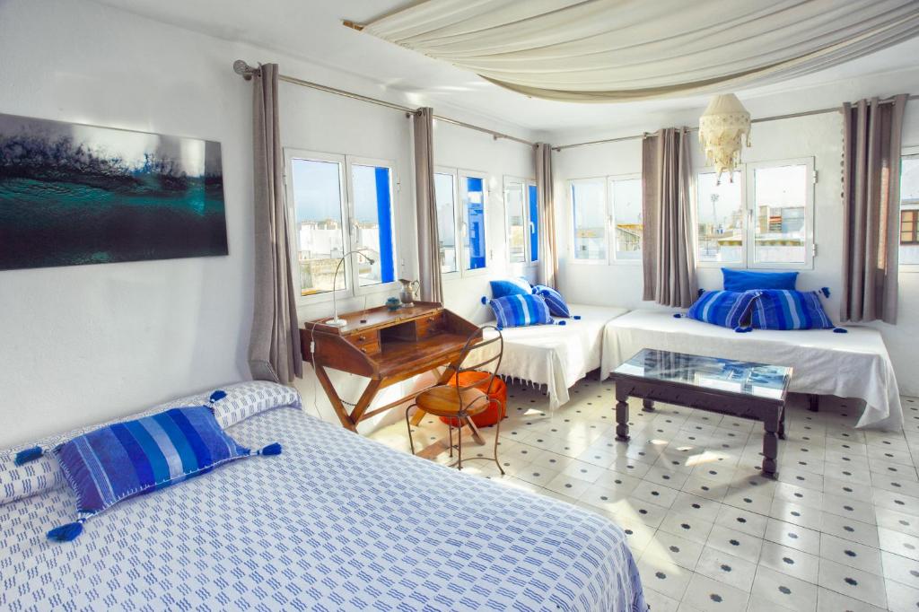 una habitación de hotel con 2 camas y un piano en La Estrella de Tarifa, en Tarifa