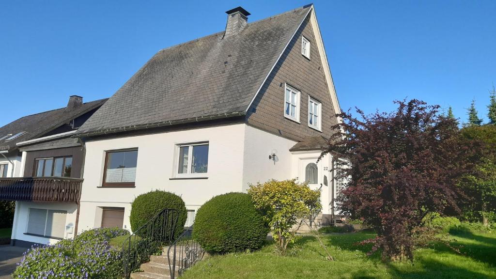 ein großes weißes Haus mit grauem Dach in der Unterkunft Ferienwohnung Zum Heideblick in Winterberg