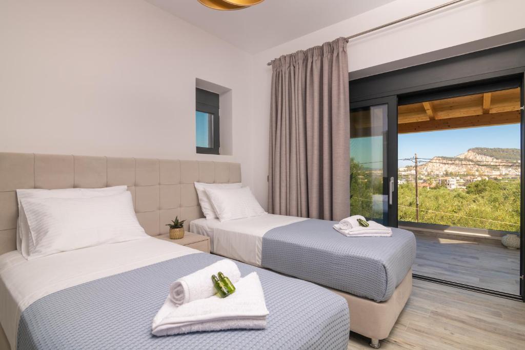 a hotel room with two beds and a balcony at Villa Olive Green in Argassi
