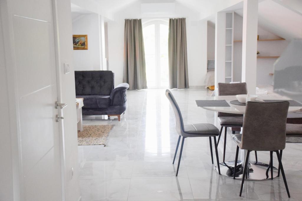- une salle à manger et un salon avec une table et des chaises dans l'établissement Villa Bella, à Golubac