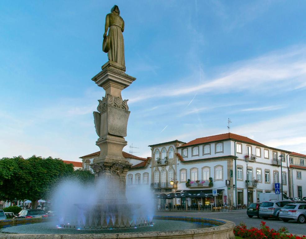 uma estátua numa fonte em frente a um edifício em Raiano Guest House em Monção