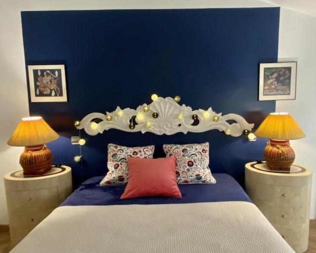 a blue bedroom with a large bed with two lamps at El Loft de Andy in Oviedo