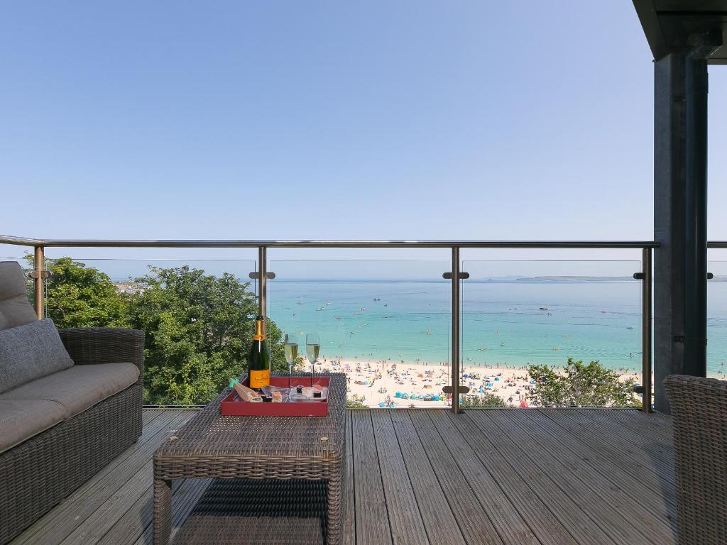 a balcony with a couch and a view of the ocean at Crystal Bay in St Ives