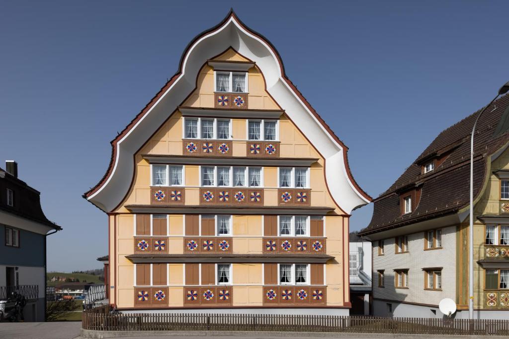 un grand bâtiment avec un toit triangulaire dans l'établissement Blattenheimat - im traditionellen Appenzeller Haus, à Appenzell