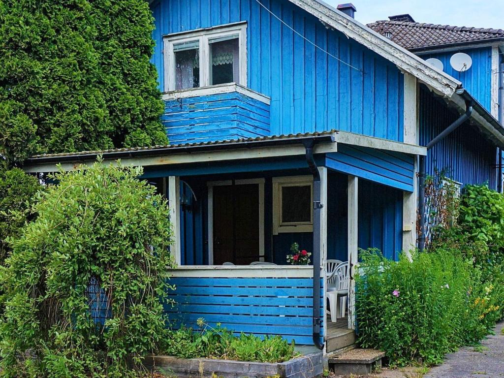 a blue house with a window and a porch at 6 person holiday home in MARIESTAD in Mariestad