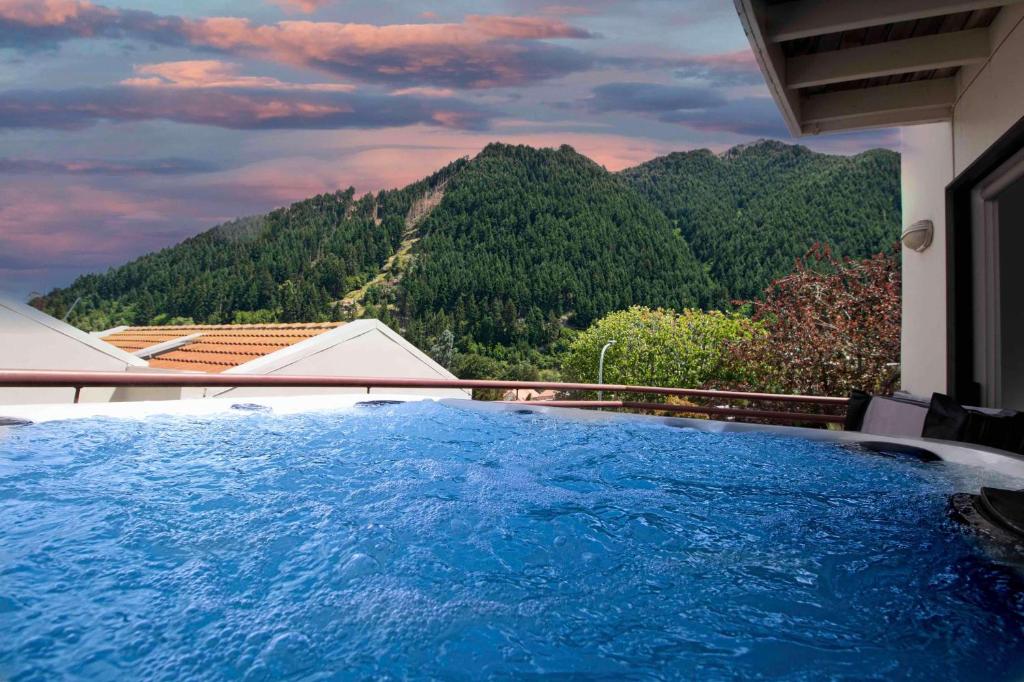 a swimming pool with a view of a mountain at Close to the Action - In Town - Spa Pool in Queenstown