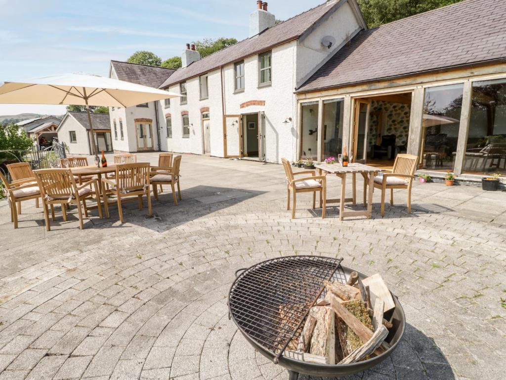 a patio with a fire pit and tables and chairs at Fron Goch Farm in Abergele