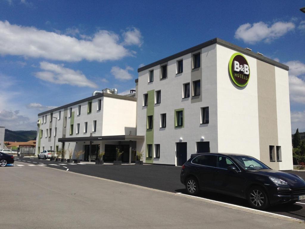 een zwarte auto geparkeerd voor een gebouw bij B&B HOTEL Aubenas in Saint-Didier-sous-Aubenas