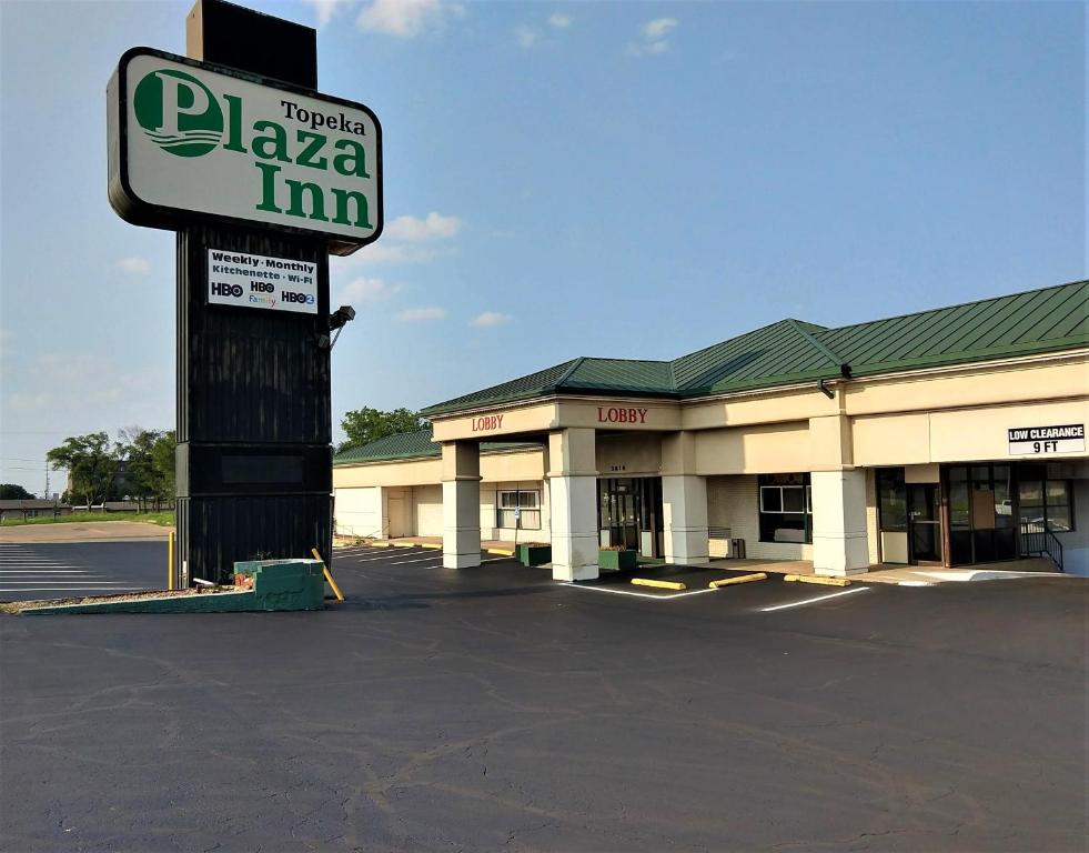 a pizza inn sign in front of a parking lot at Plaza Inn in Topeka