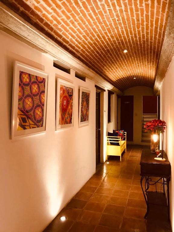 a hallway with paintings on the walls and a ceiling at Luna Maya Antigua in Antigua Guatemala