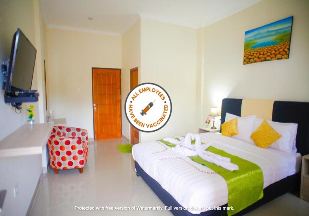 una camera da letto con un letto con un orologio sul muro di Pavilla Labuan Bajo a Labuan Bajo