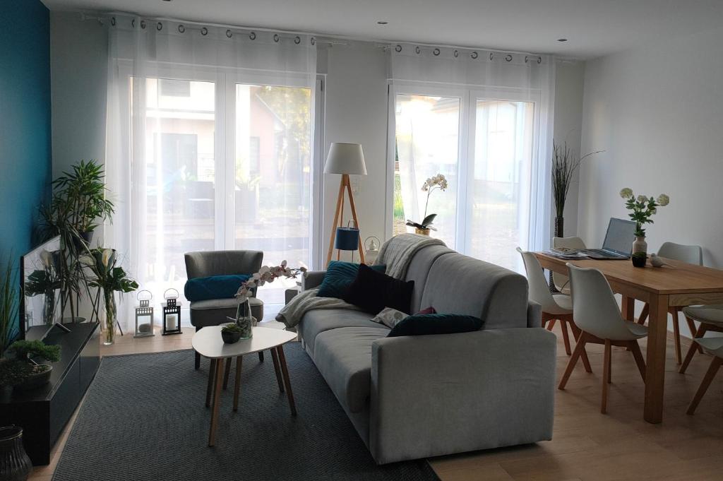 uma sala de estar com um sofá e uma mesa em LA MAISON BLEUE, à 20 mn de Strasbourg, sur la route des vins, jusqu'à 6 personnes, Sélestat em Sélestat
