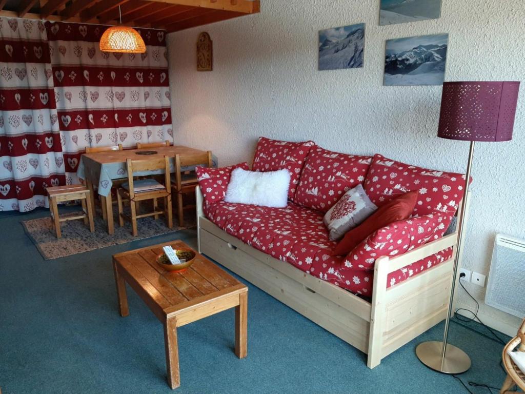 a living room with a red couch and a table at Appartement Villard-de-Lans, 2 pièces, 6 personnes - FR-1-515-31 in Villard-de-Lans