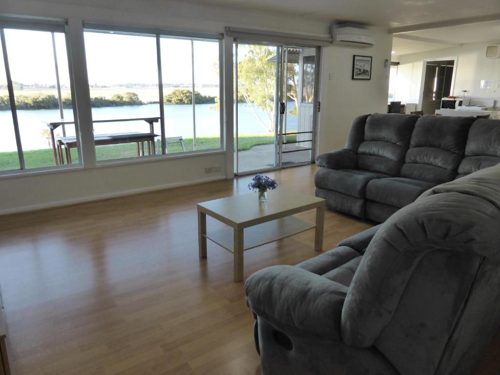 a living room with a couch and a table at Riverfront Holiday House in Wellington East