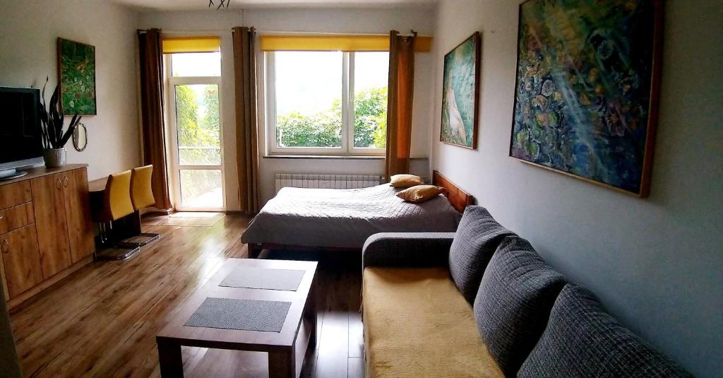 a living room with a couch and a bed at Apartament Tylas 2 in Jaworki