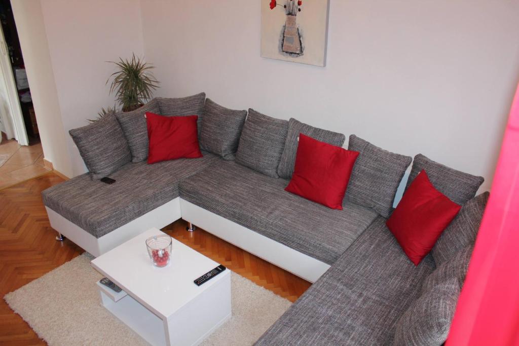 a living room with a gray couch with red pillows at Apartment MeliRa in Novi Vinodolski