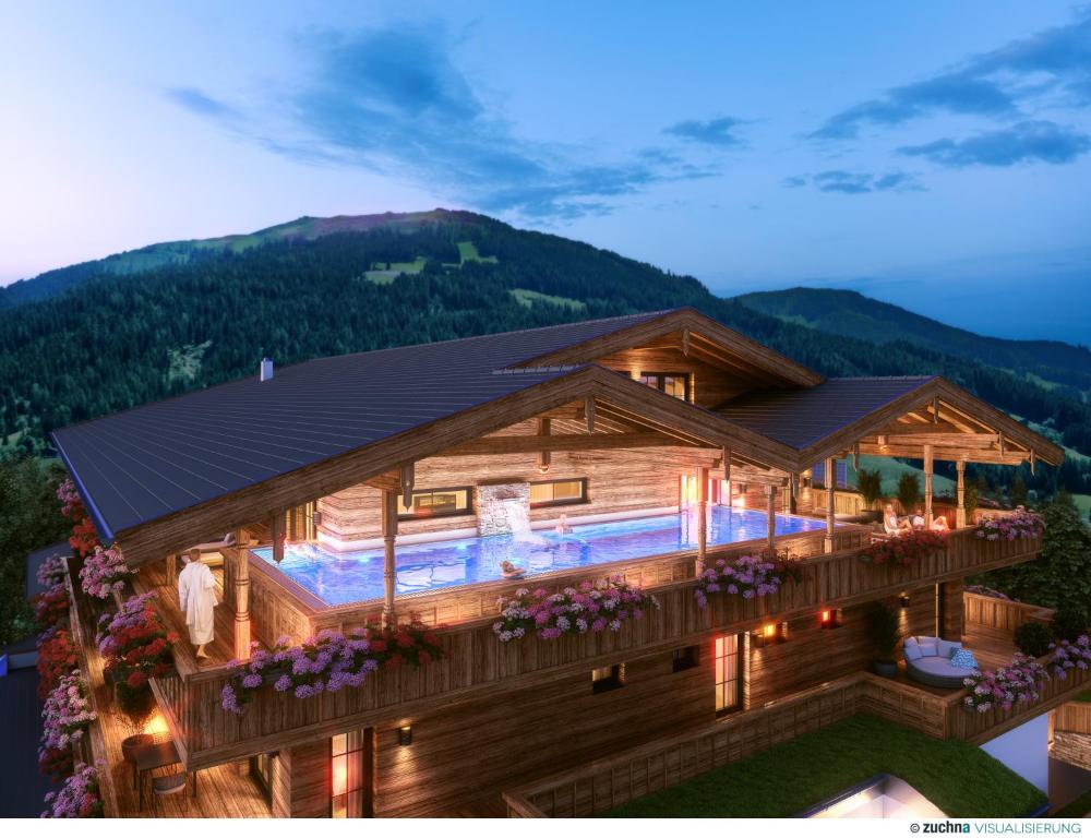 ein Holzhaus mit Bergen im Hintergrund in der Unterkunft Boutiquehotel die Alpbacherin 4 Sterne Superior in Alpbach