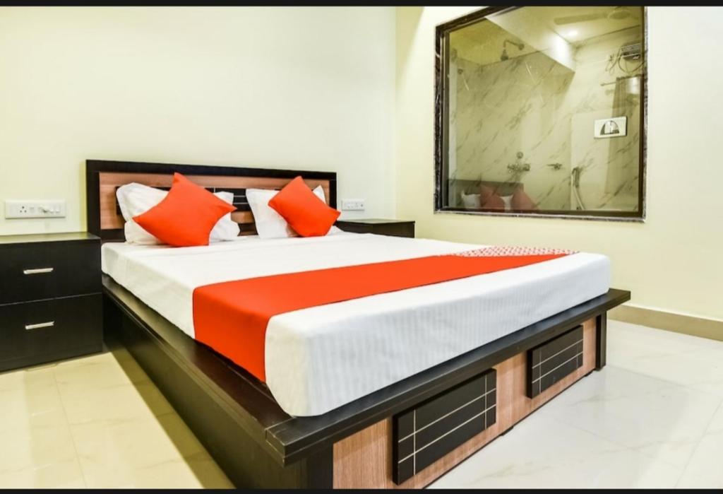 een slaapkamer met een groot bed met oranje kussens bij Silver Key Suites in Nagpur