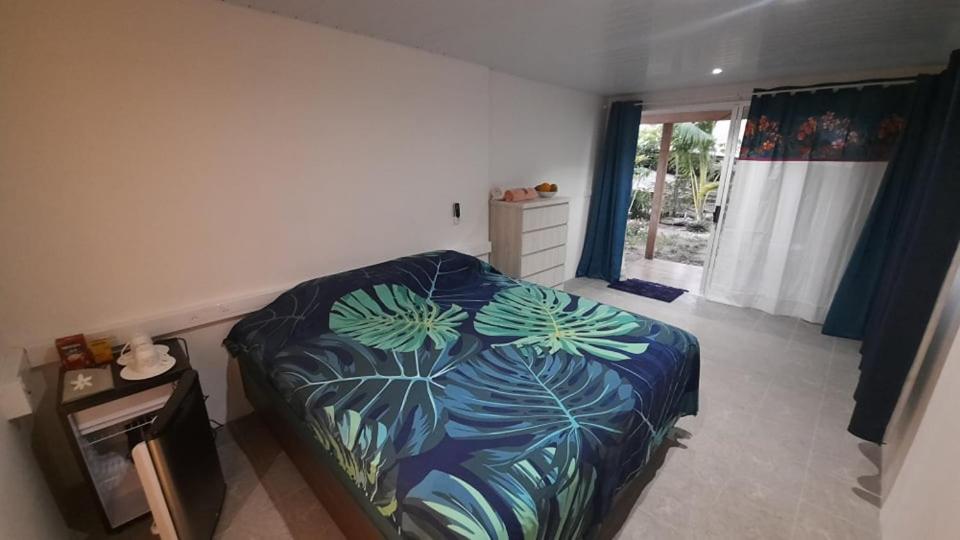 a bedroom with a bed with a blue comforter at Matira house in Bora Bora
