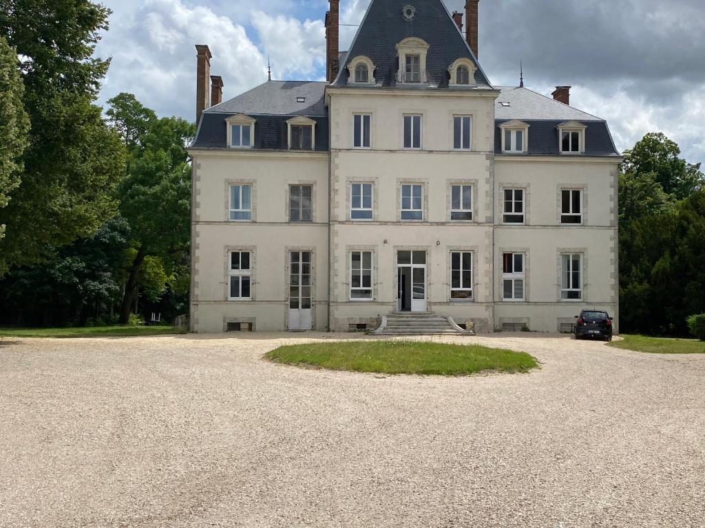 una gran casa blanca con techo negro en Le château de Courbouzon, en Courbouzon