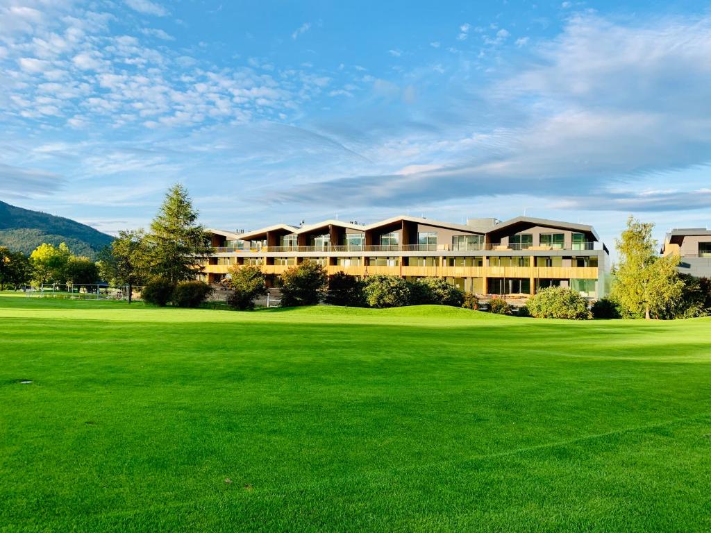 Blick auf ein Resort mit einem großen grünen Feld in der Unterkunft Teehouse Golf Apartment in Čeladná