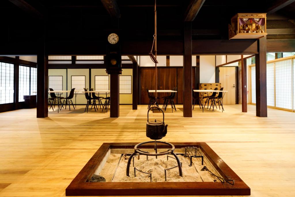 um quarto com uma mesa e cadeiras e um relógio em Denpaku Komatsu em Komatsu