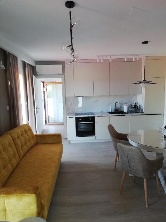 a living room with a couch and a table at Apartament Latarnik- Yellow in Gąski