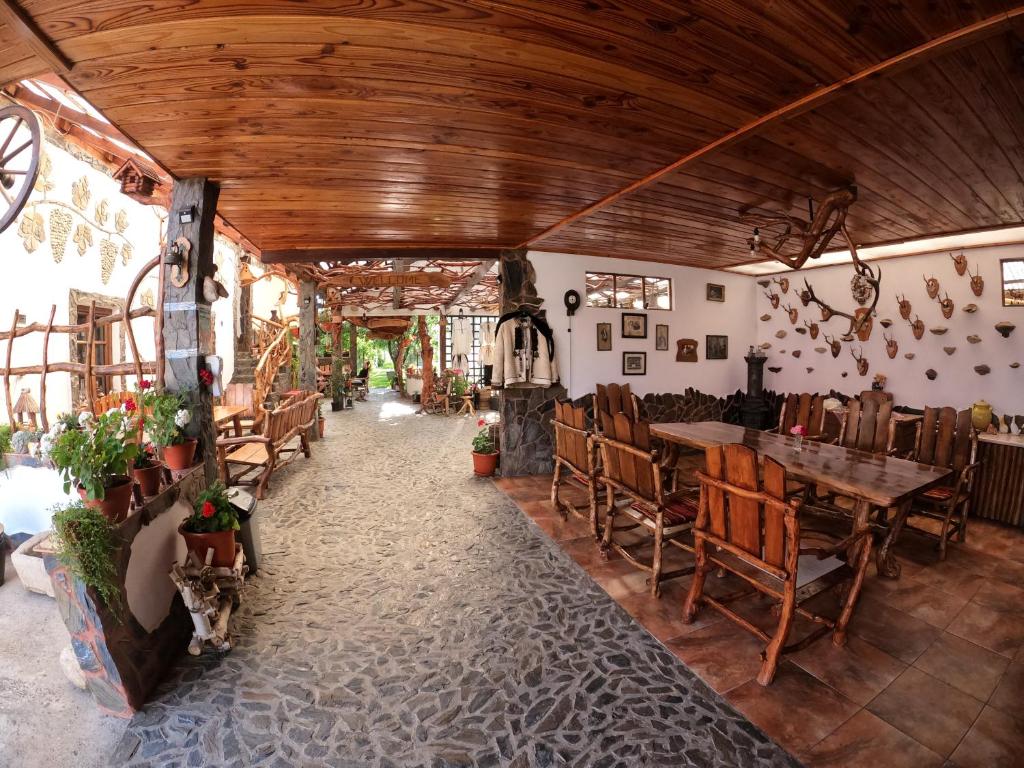 restauracja z drewnianymi sufitami, stołami i krzesłami w obiekcie Casa Vlad w mieście Haţeg