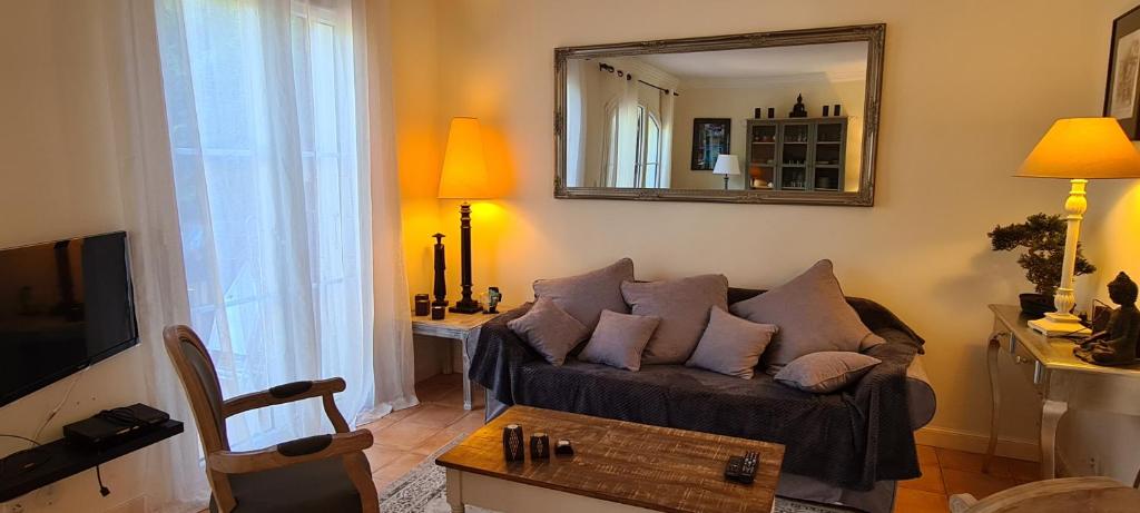 a living room with a couch and a mirror at Le Petit Mas de Grimaud in Grimaud