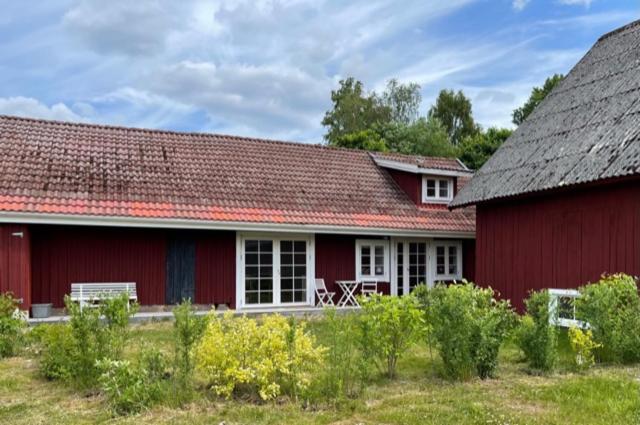 uma casa vermelha com um telhado vermelho em Brogård - gårdlejlighed em Agunnaryd