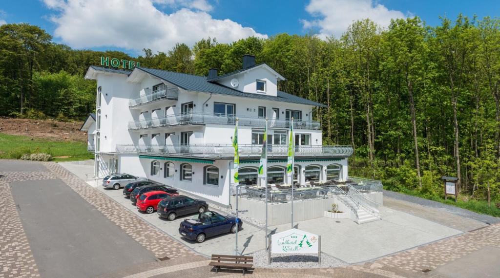 an aerial view of a large white building with cars parked in front at Landhotel Kristall in Bad Marienberg