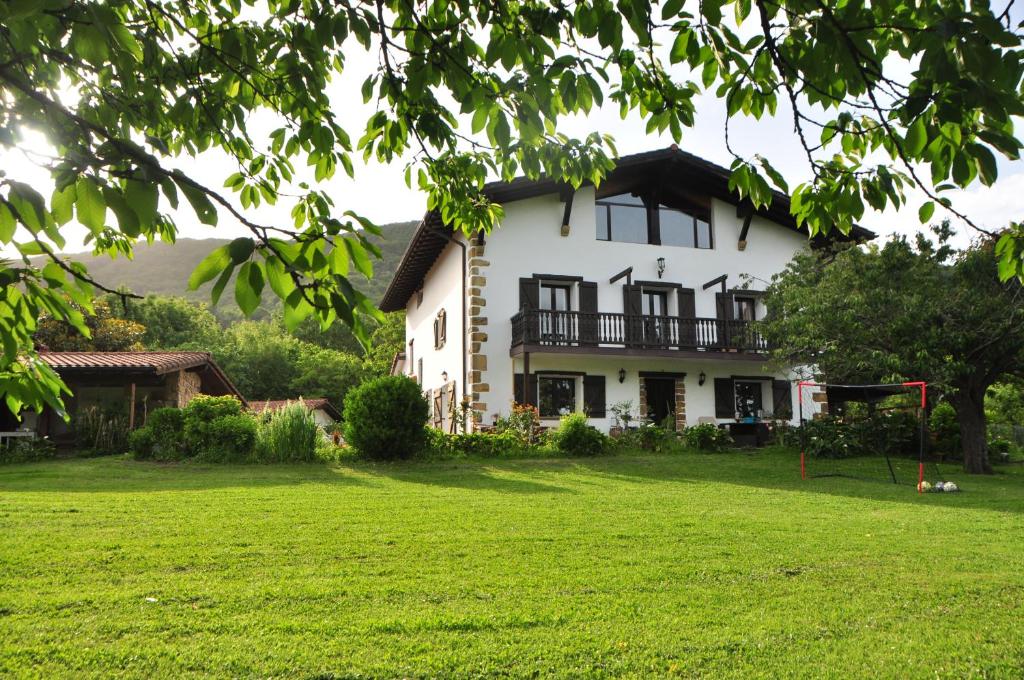 een groot wit huis met een grote tuin bij CASA MENDILORE in Hondarribia