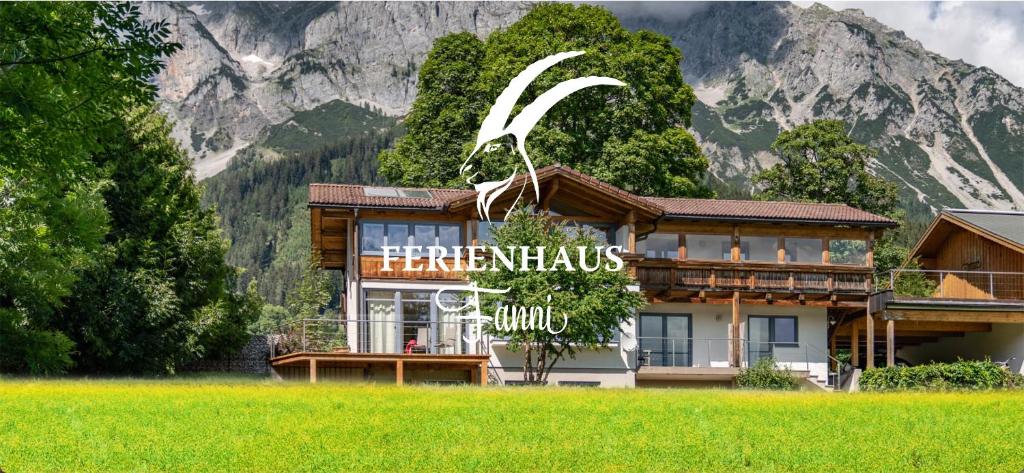 un hotel con un cartel en él delante de una montaña en Ferienhaus Fanni en Ramsau am Dachstein