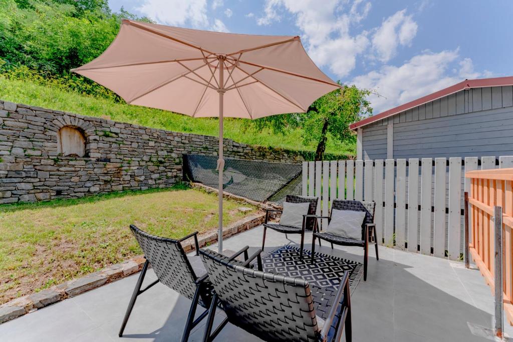 une terrasse avec 4 chaises et un parasol dans l'établissement Garden.Lodge Spitz in der Wachau, à Spitz