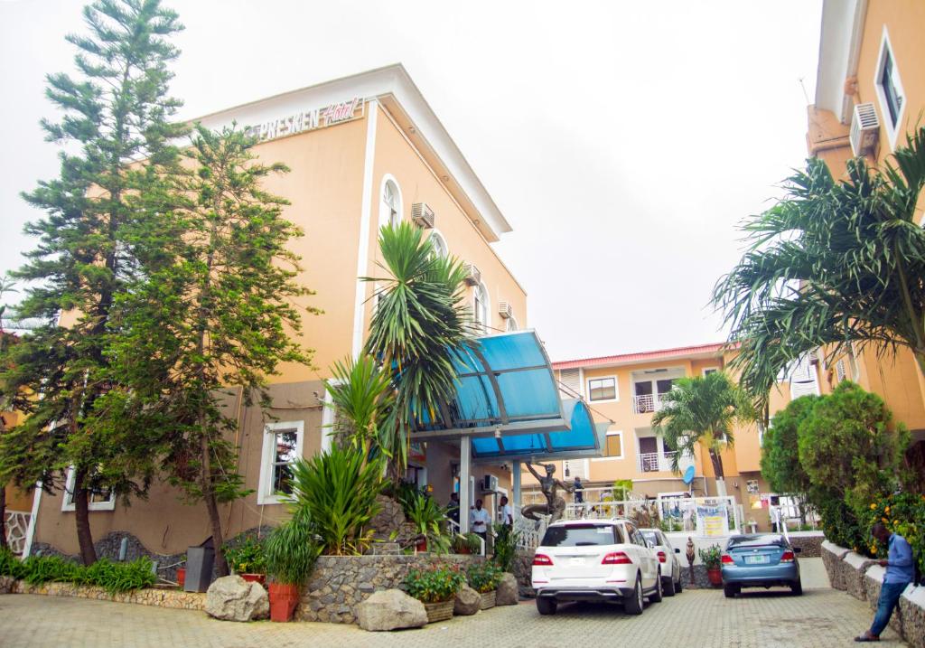 a building with cars parked in front of it at Presken Hotels Opebi Lagos in Ikeja