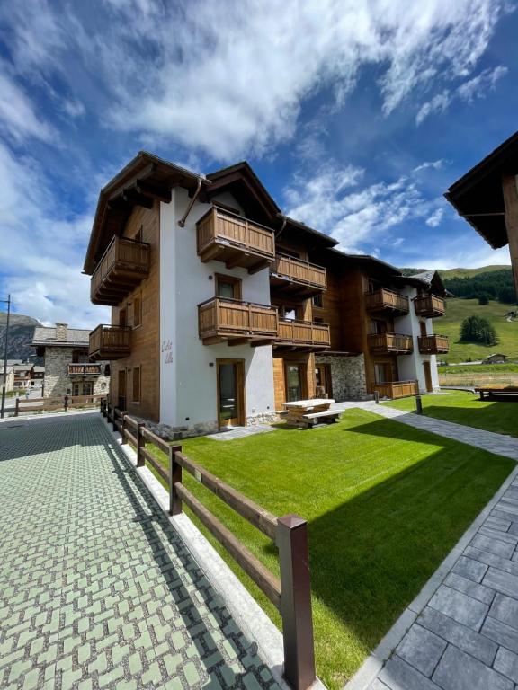 ein Haus mit grünem Rasen davor in der Unterkunft Chalet Lilla Livigno in Livigno