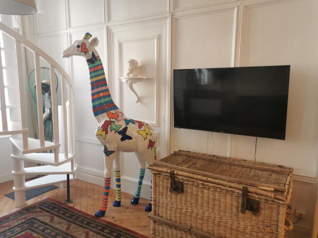 een beeld van een giraf die naast een tv staat bij Les Papillons de St Leonard in Honfleur