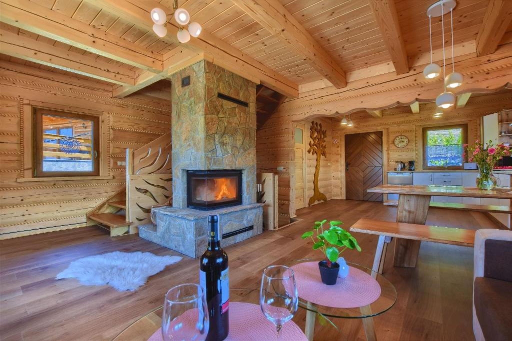 a living room with a fireplace in a log cabin at Domki inNatura in Istebna