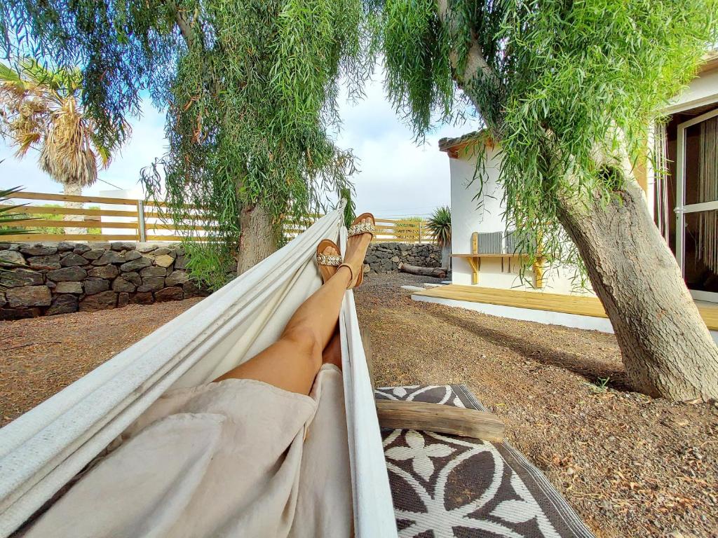 a person laying in a hammock with their feet up at Casa Cocoloe Lajares in Lajares