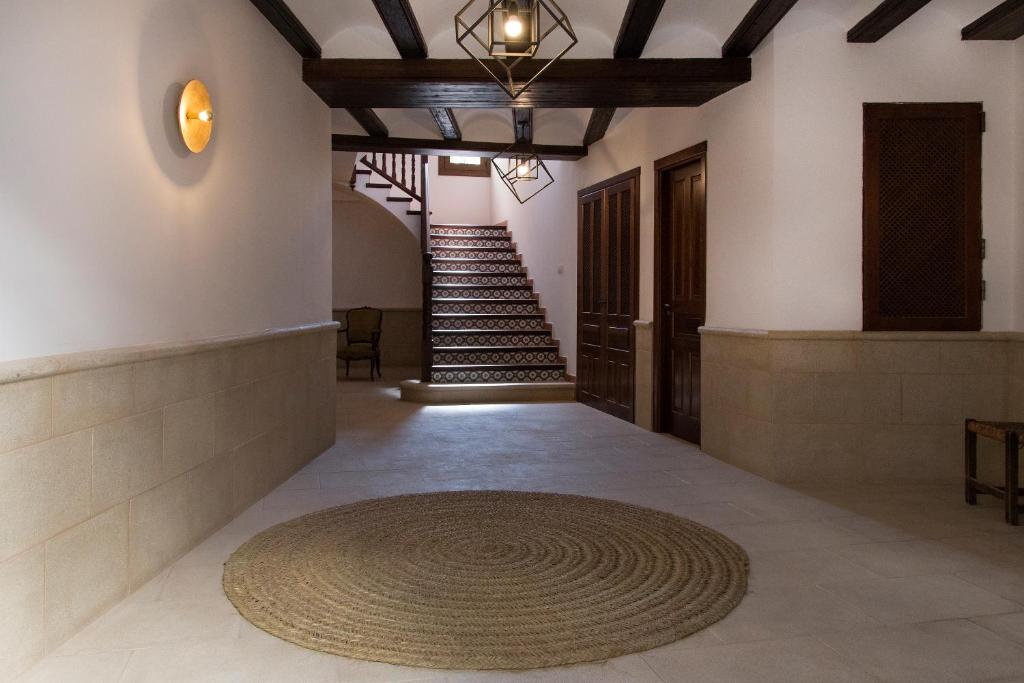 a hallway with a spiral staircase and a rug on the floor at CASA RURAL ADUANA in Rubielos de Mora