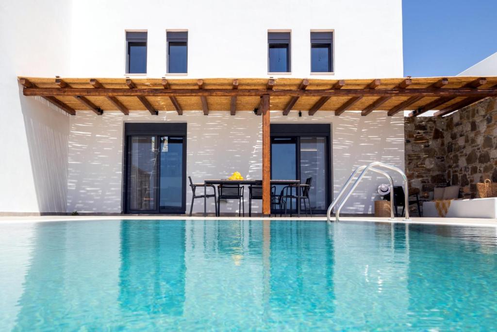 een villa met een zwembad en een huis bij Cato Agro 4, Seafront Villa with Private Pool in Karpathos