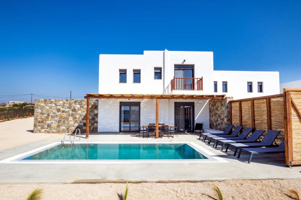 a villa with a swimming pool in front of a house at Cato Agro 5, Seafront Villa with Private Pool in Karpathos